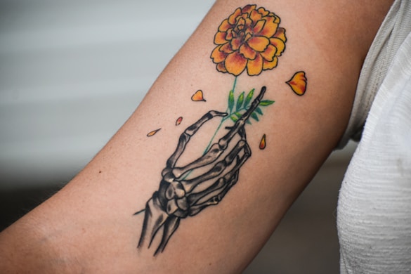 A person with a tattoo on their arm holding a flower