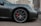 A grey sports car parked in front of a building