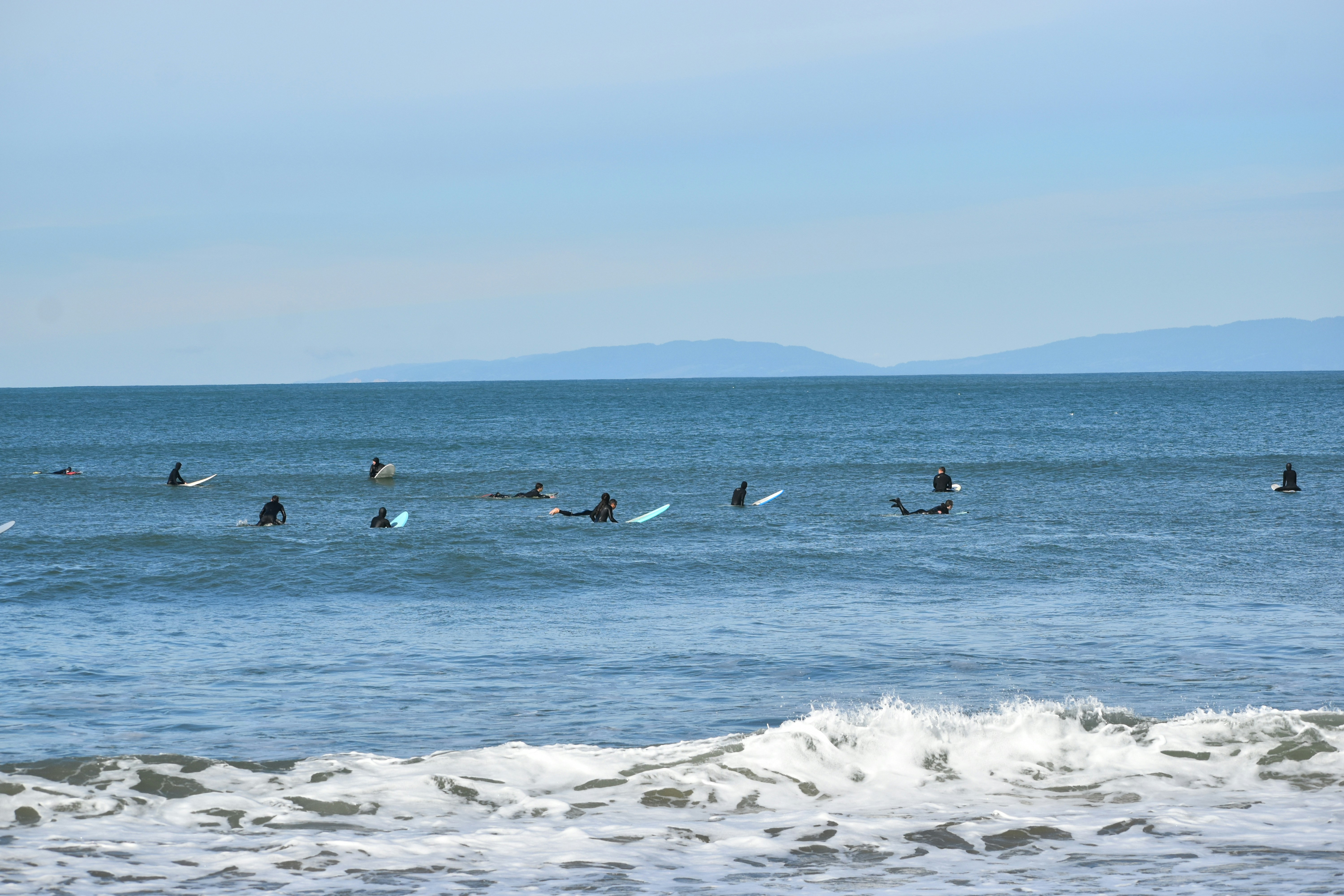 A group of people riding surfboards on top of a wave