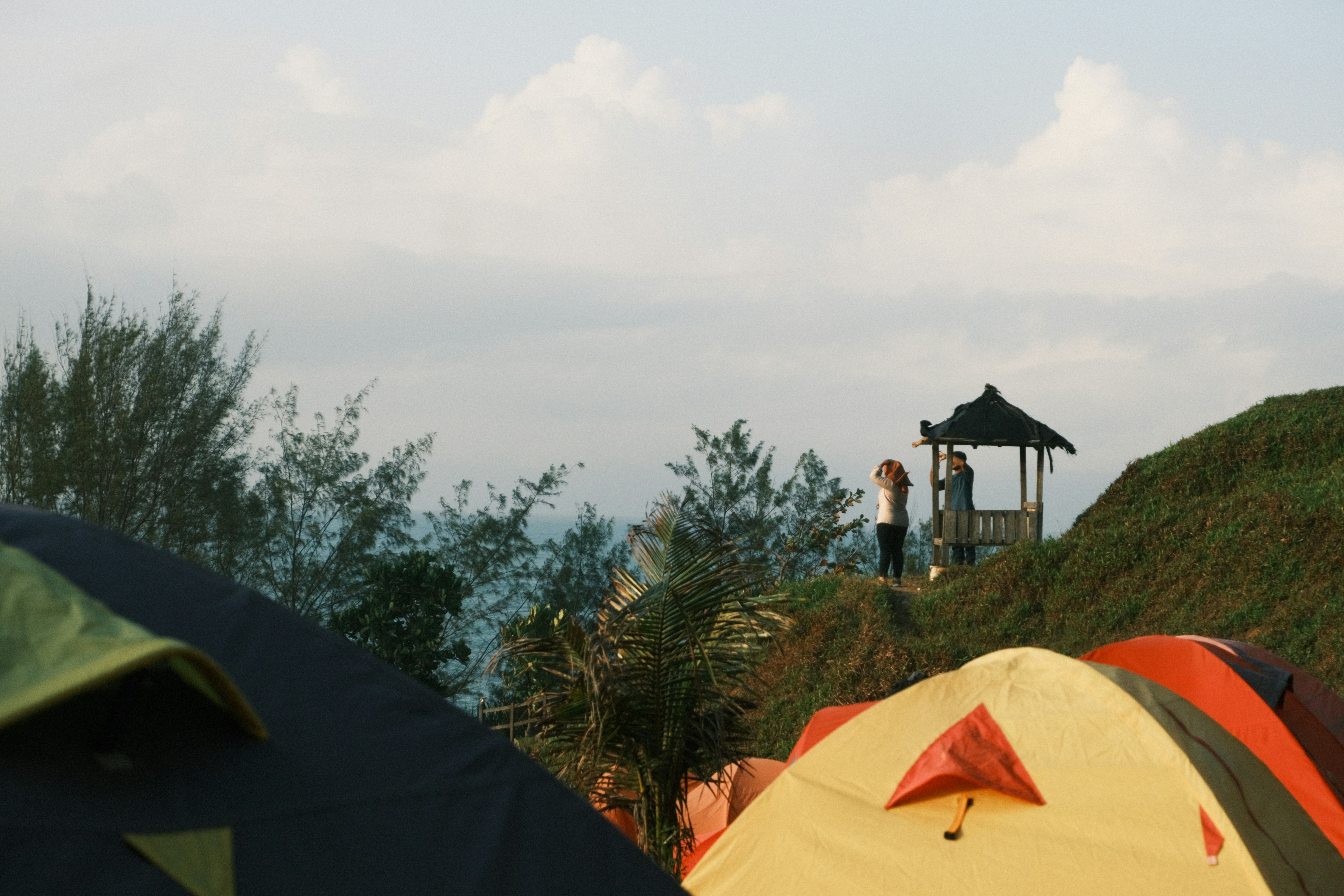 A group of tents sitting on top of a lush green hillside