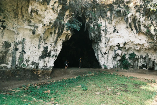 A person standing in a cave with a bike