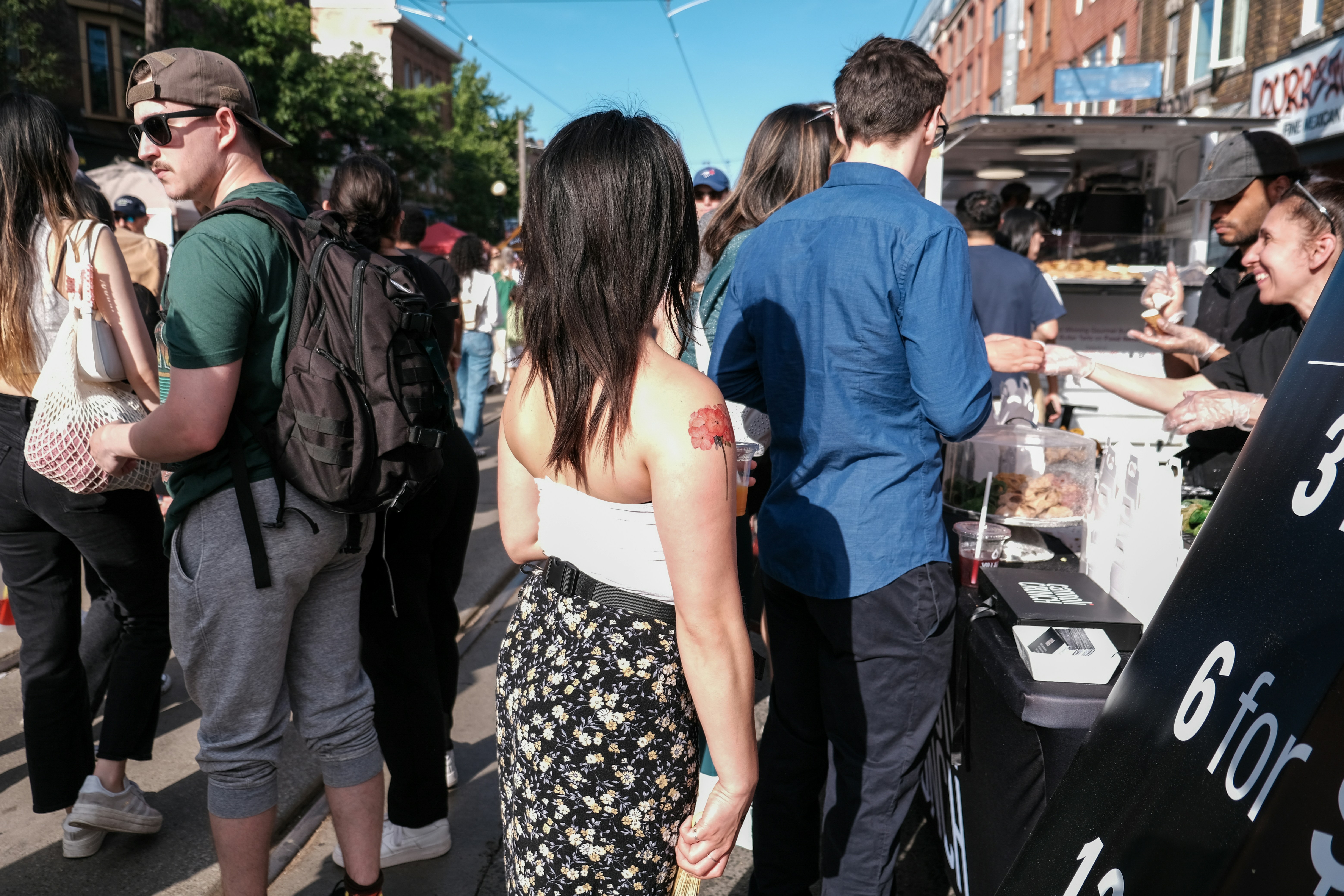 A group of people standing around a food stand