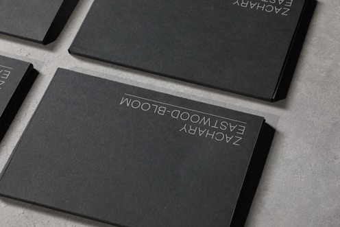 A group of four black books sitting on top of a table