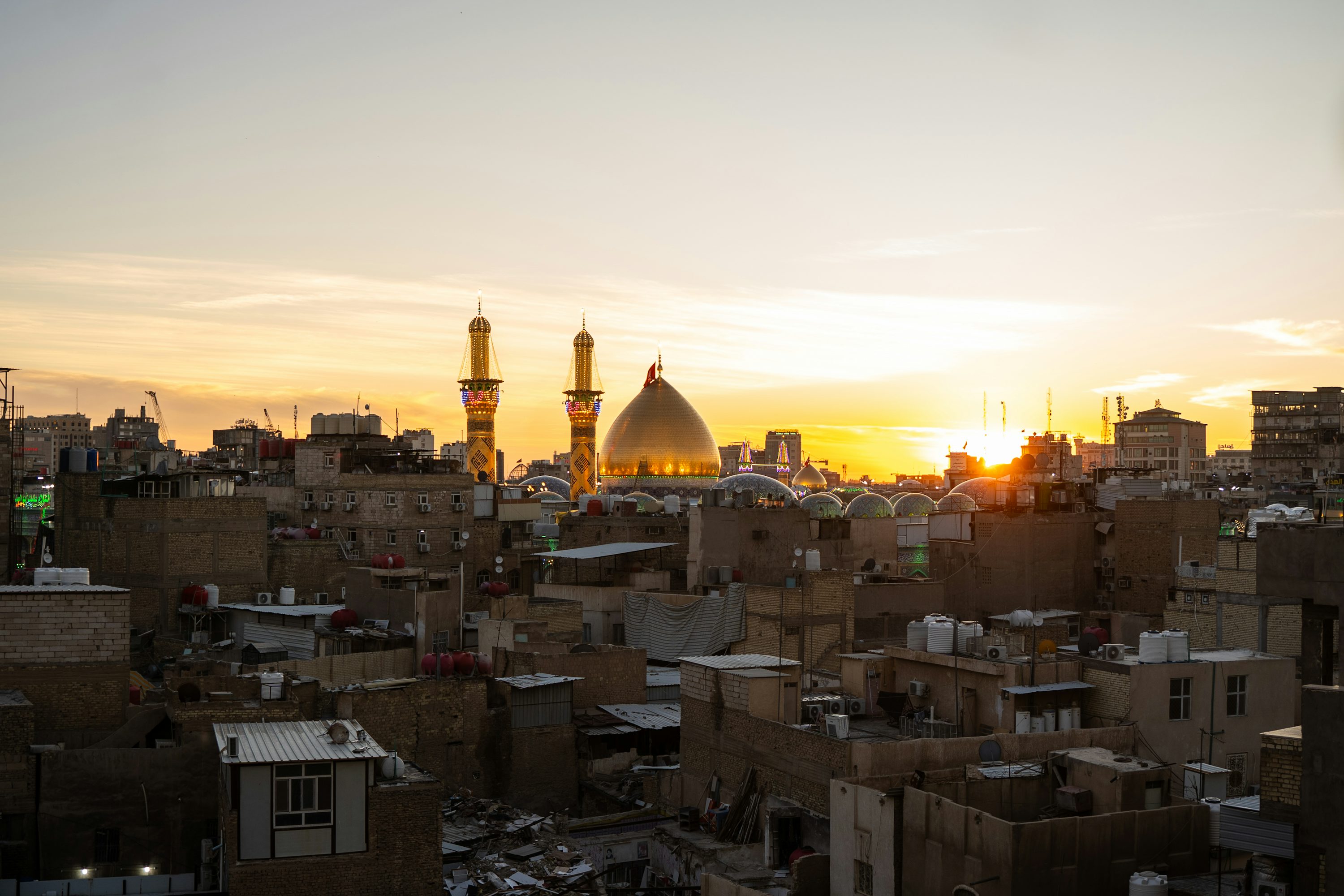 The sun is setting over a city with tall buildings