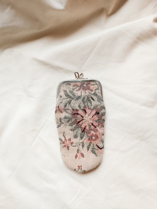 A small purse sitting on top of a white sheet