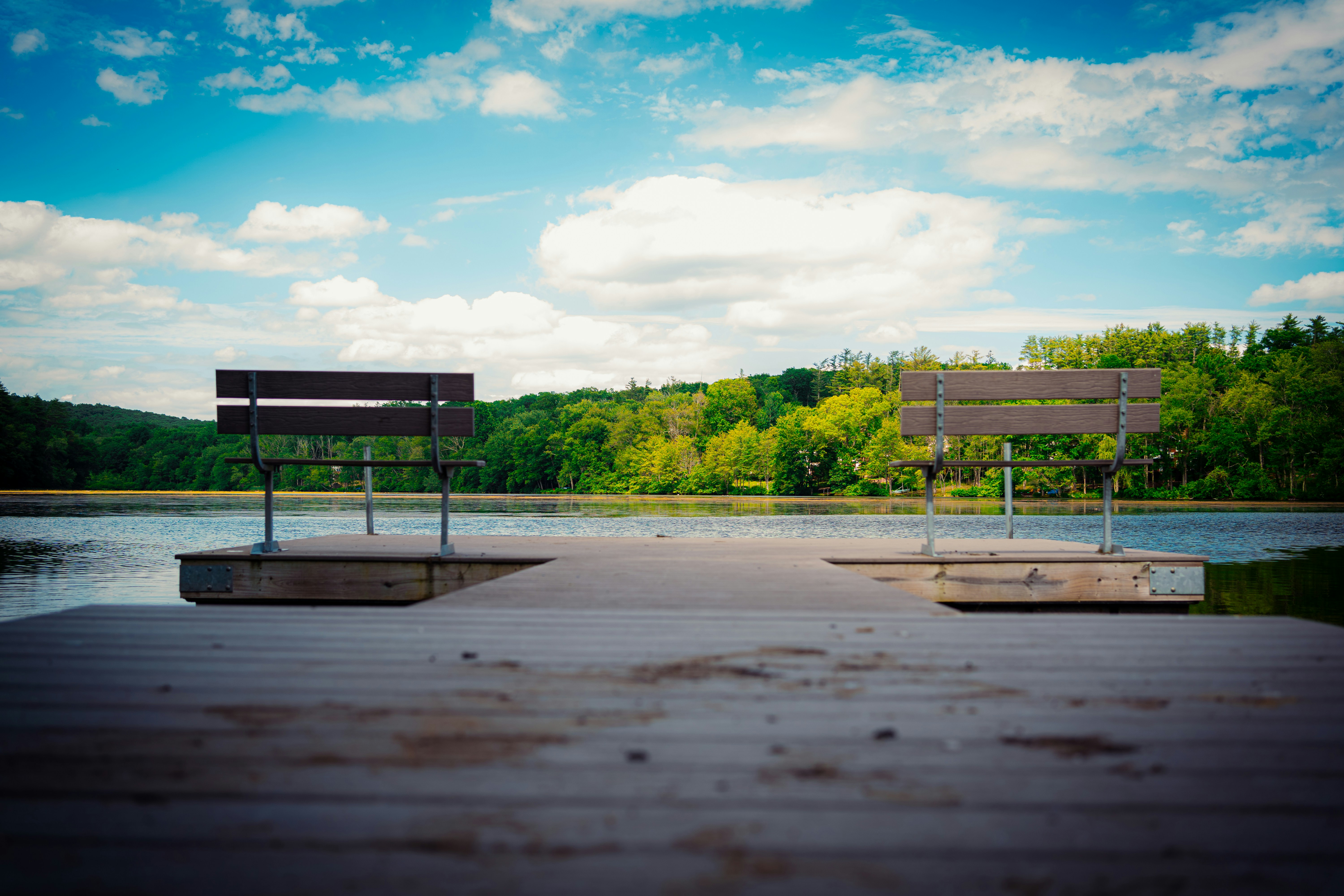 A bench sitting on top of a wooden pier next to a lake