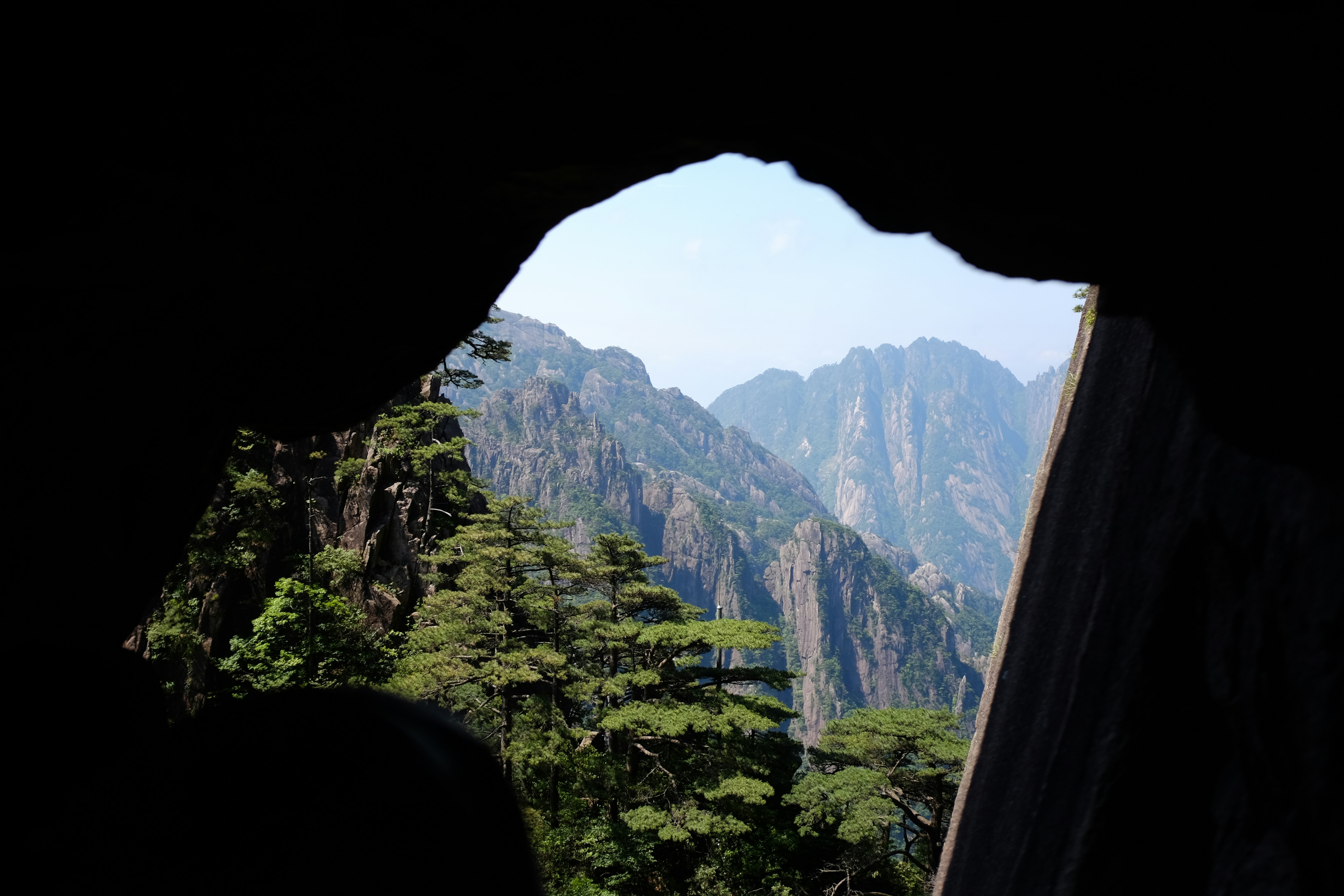 A view of a mountain range through a cave