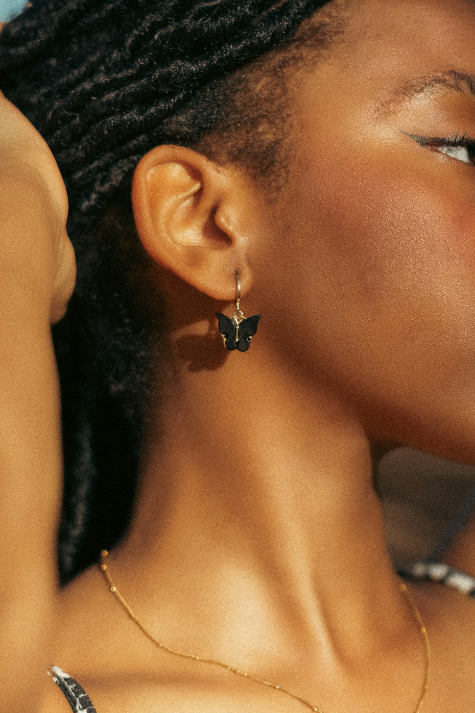 A close up of a person wearing a necklace and earrings