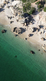 An aerial view of a beach with a boat in the water
