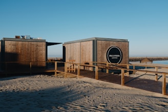 A couple of wooden buildings sitting on top of a sandy beach