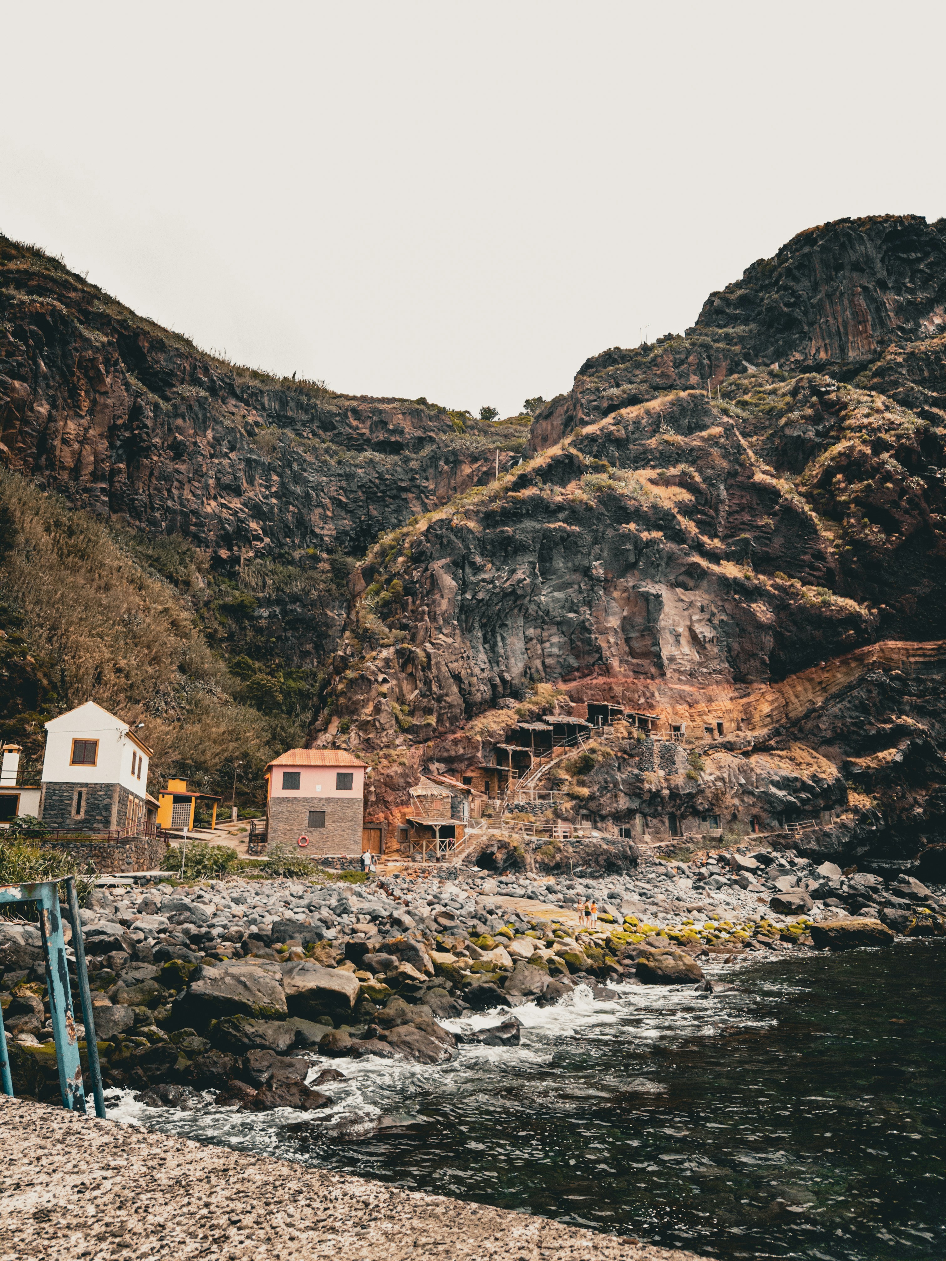 A house on a rocky shore next to a body of water