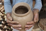 A person holding a clay pot in their hands