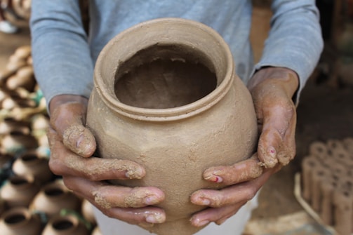 A person holding a clay pot in their hands