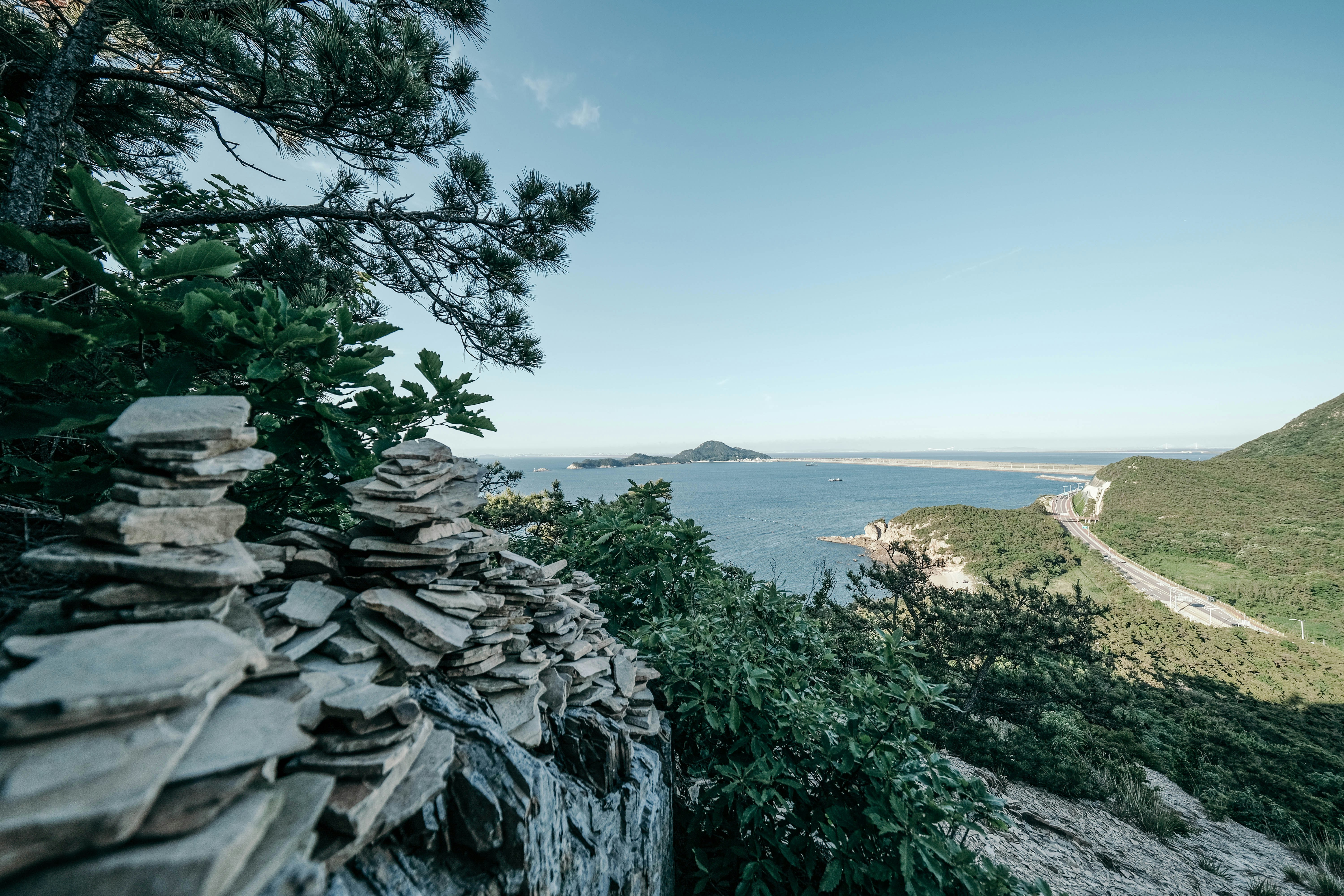 Stop image for Lowcountry to Blue Ridge: 3-Day Spring Road Trip - A rocky cliff overlooks a body of water -  in Southeast USA - Photo by insung yoon on Unsplash
