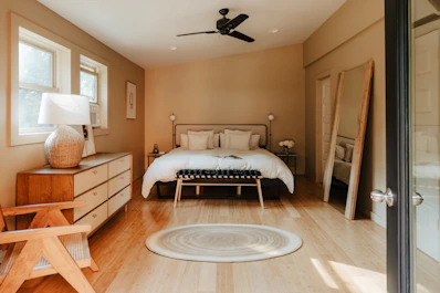 A bedroom with a bed, dresser, and a window