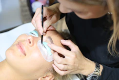 A woman getting her eyebrows done by a professional makeup artist