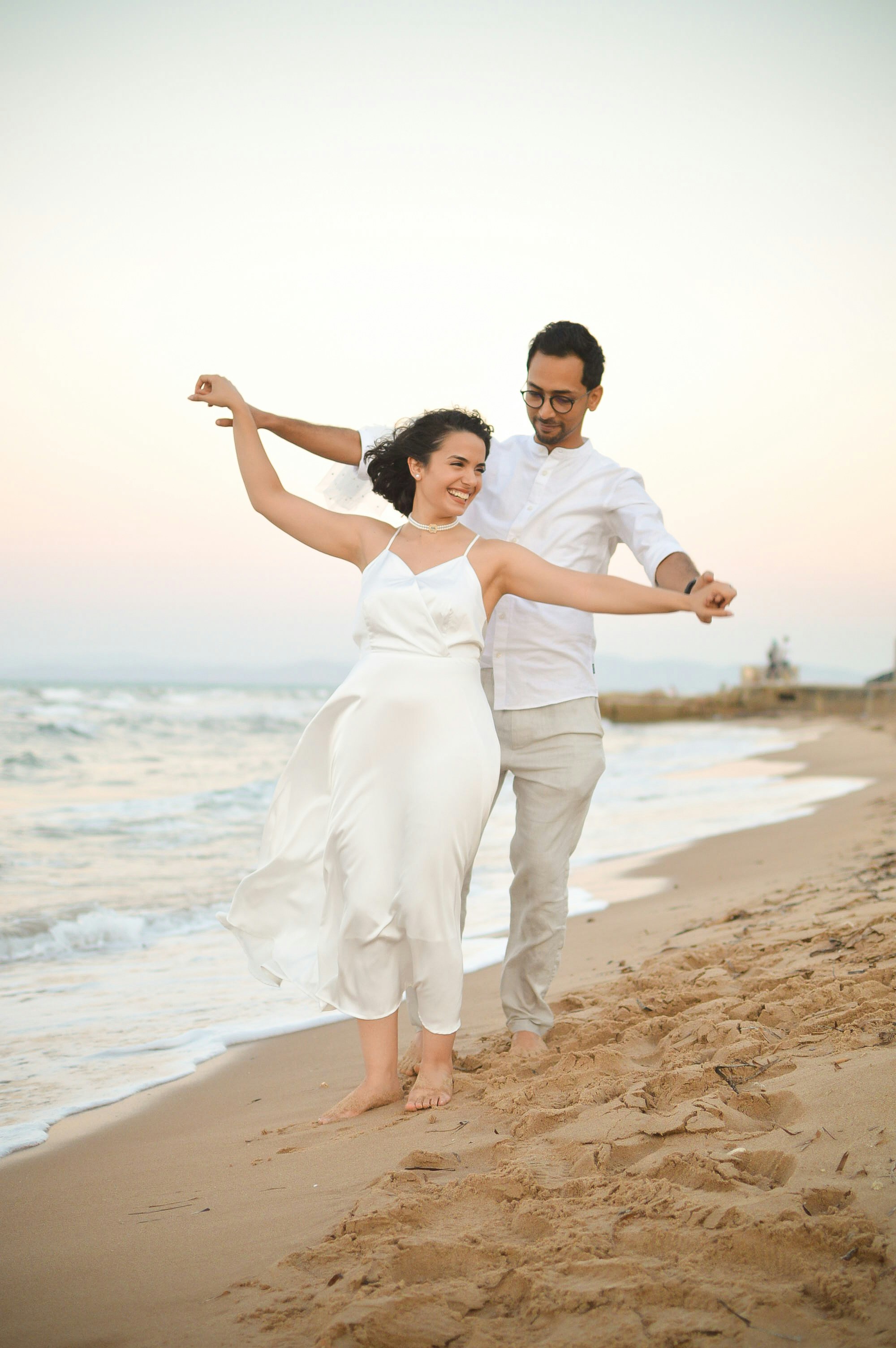 A man and a woman are running on the beach