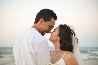 A bride and groom kissing on the beach