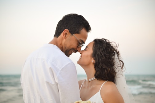 A bride and groom kissing on the beach