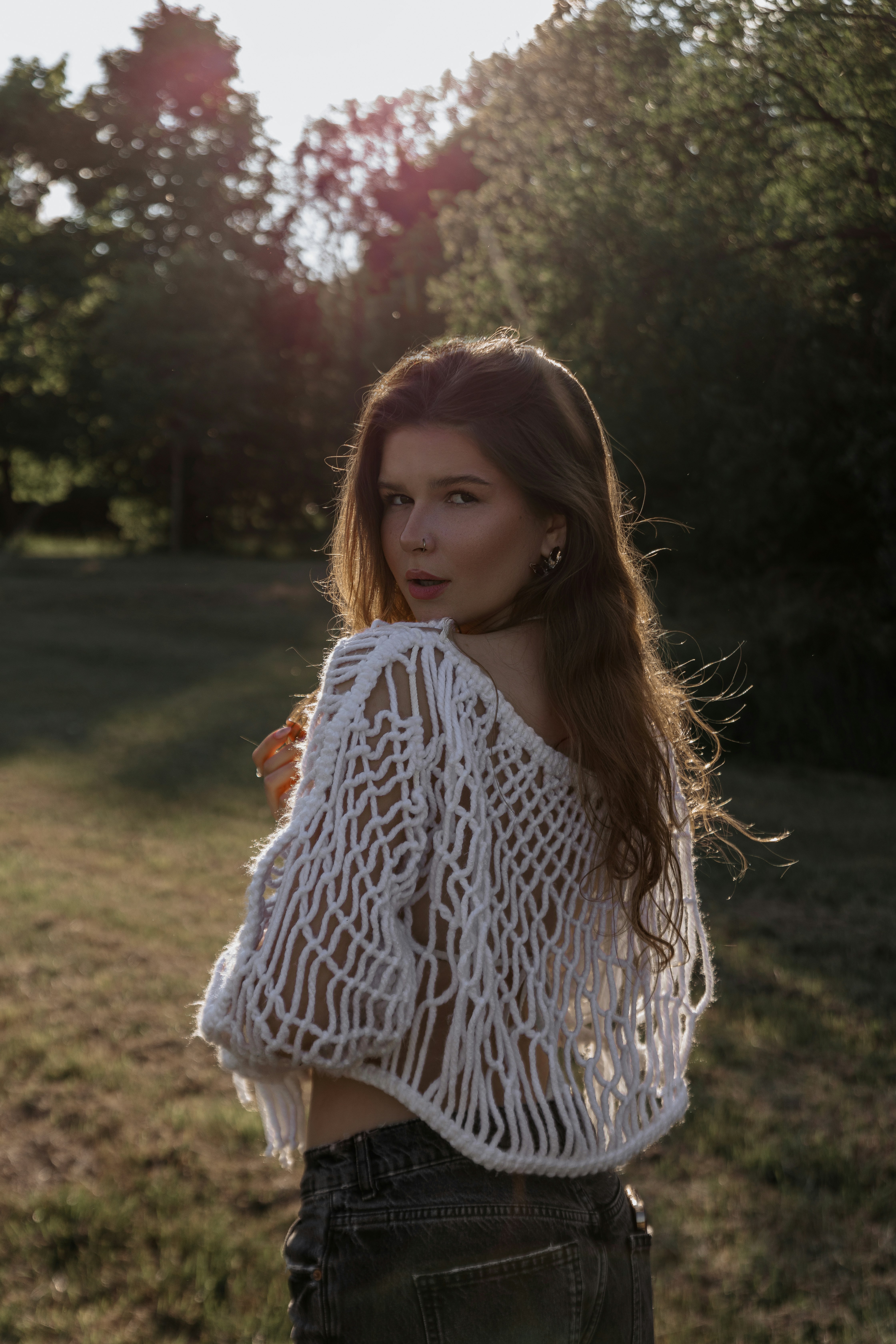 A woman standing in a field with her hands on her hips