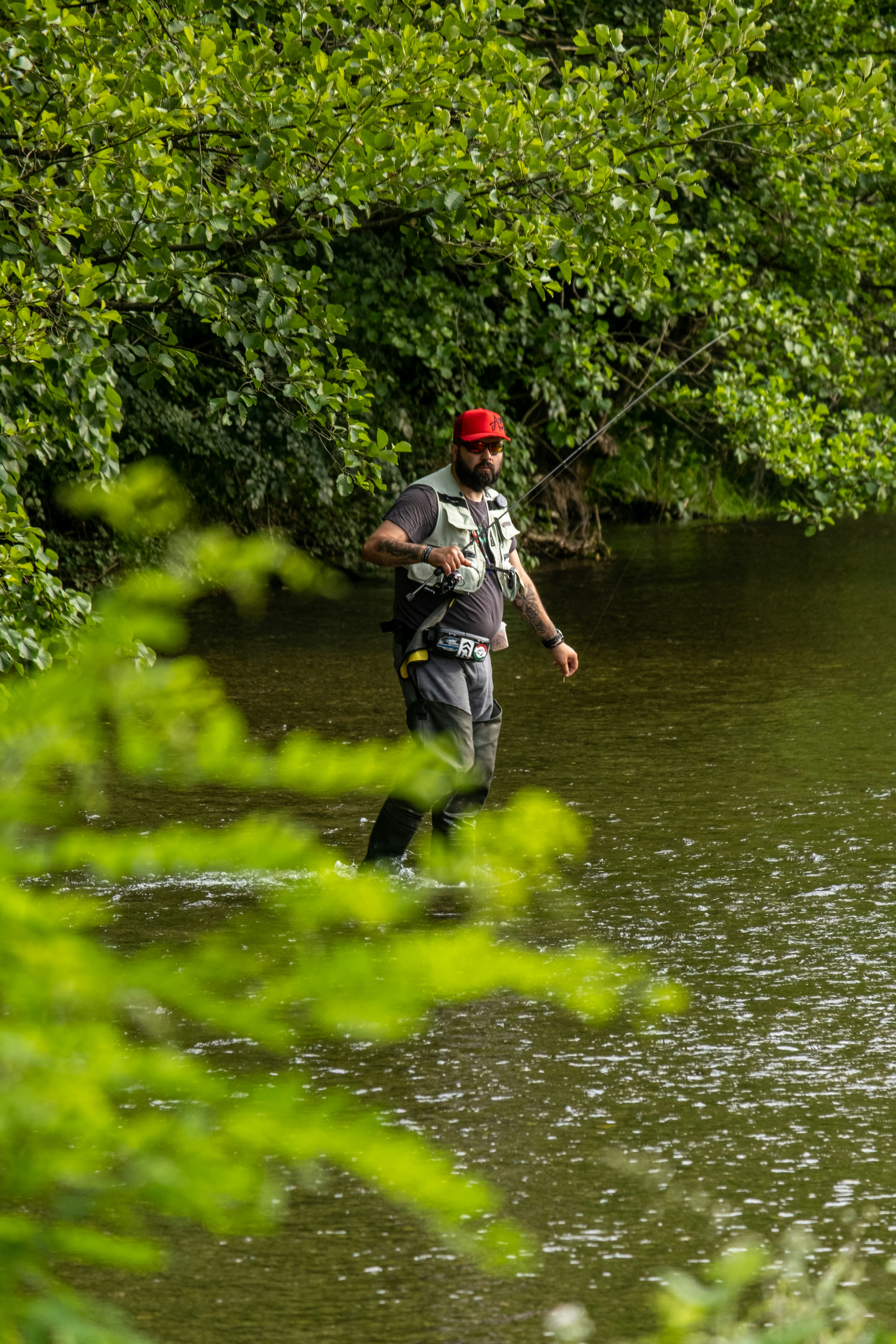 A man is wading through the water in a river