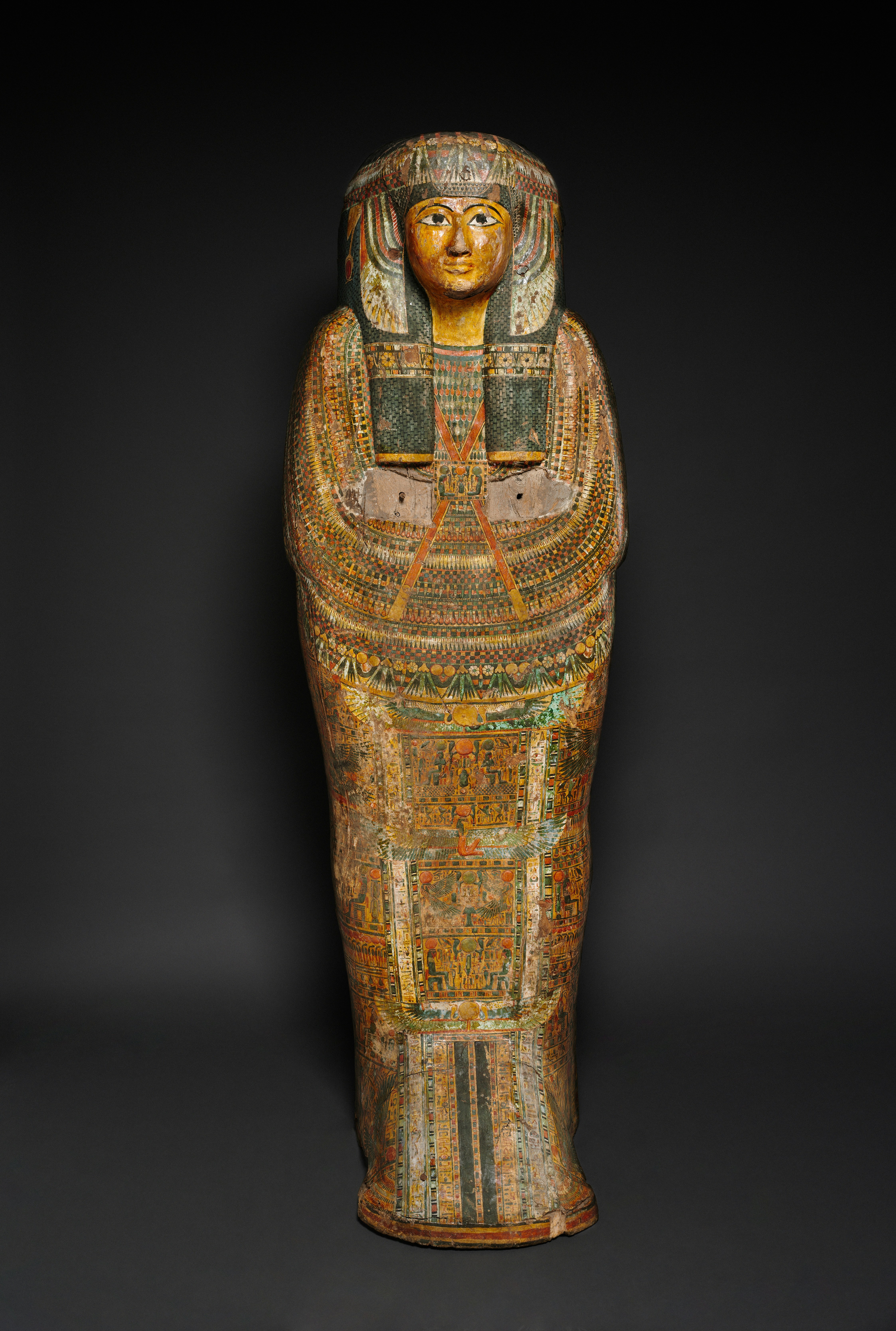 Sarcófago do antigo Egito ricamente decorado contra fundo escuro.