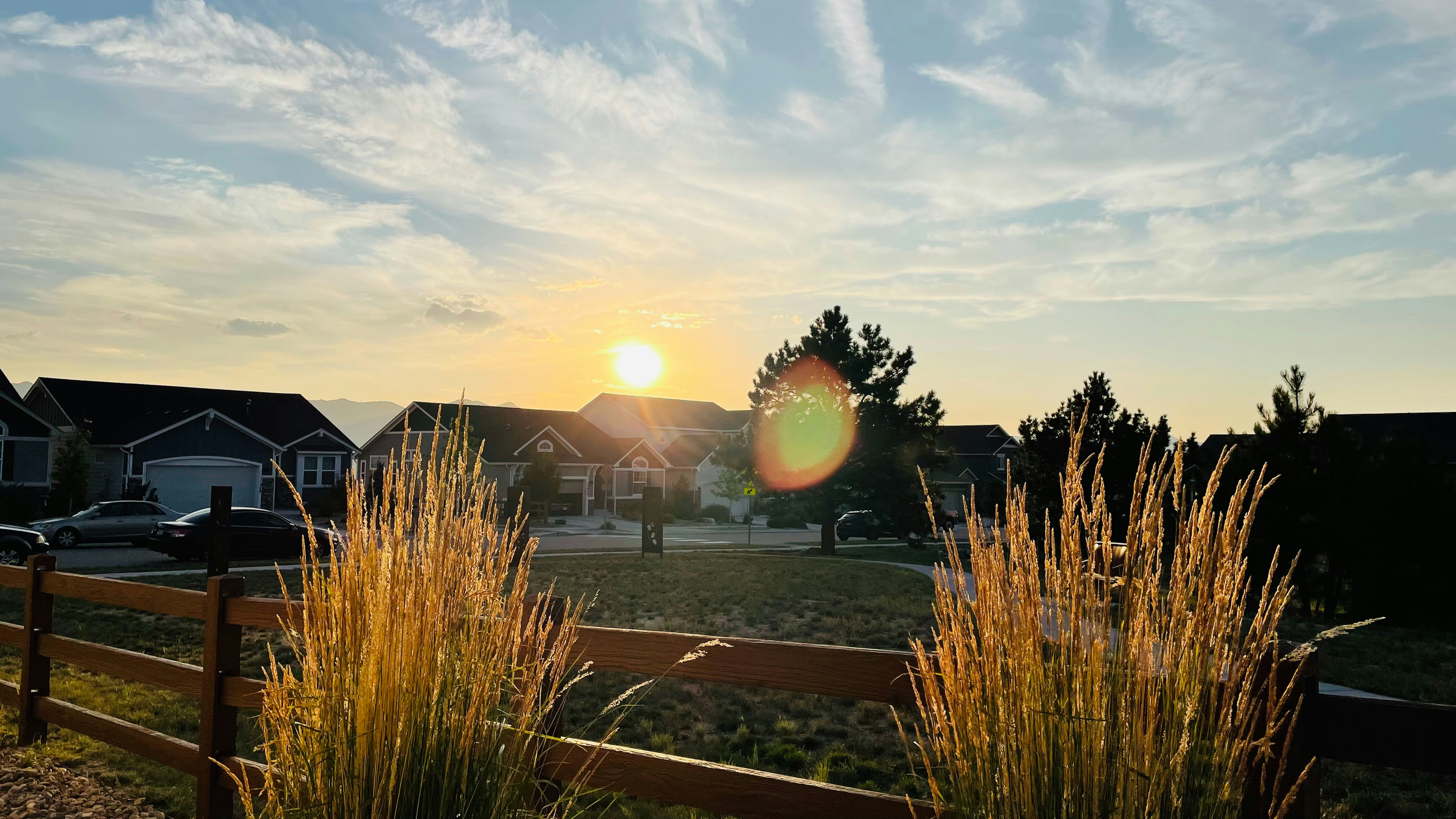 American family in front of their home smiling, suburban neighborhood, warm golden hour light