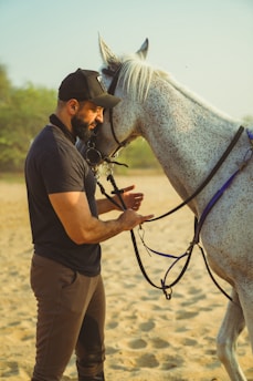 A man standing next to a white horse