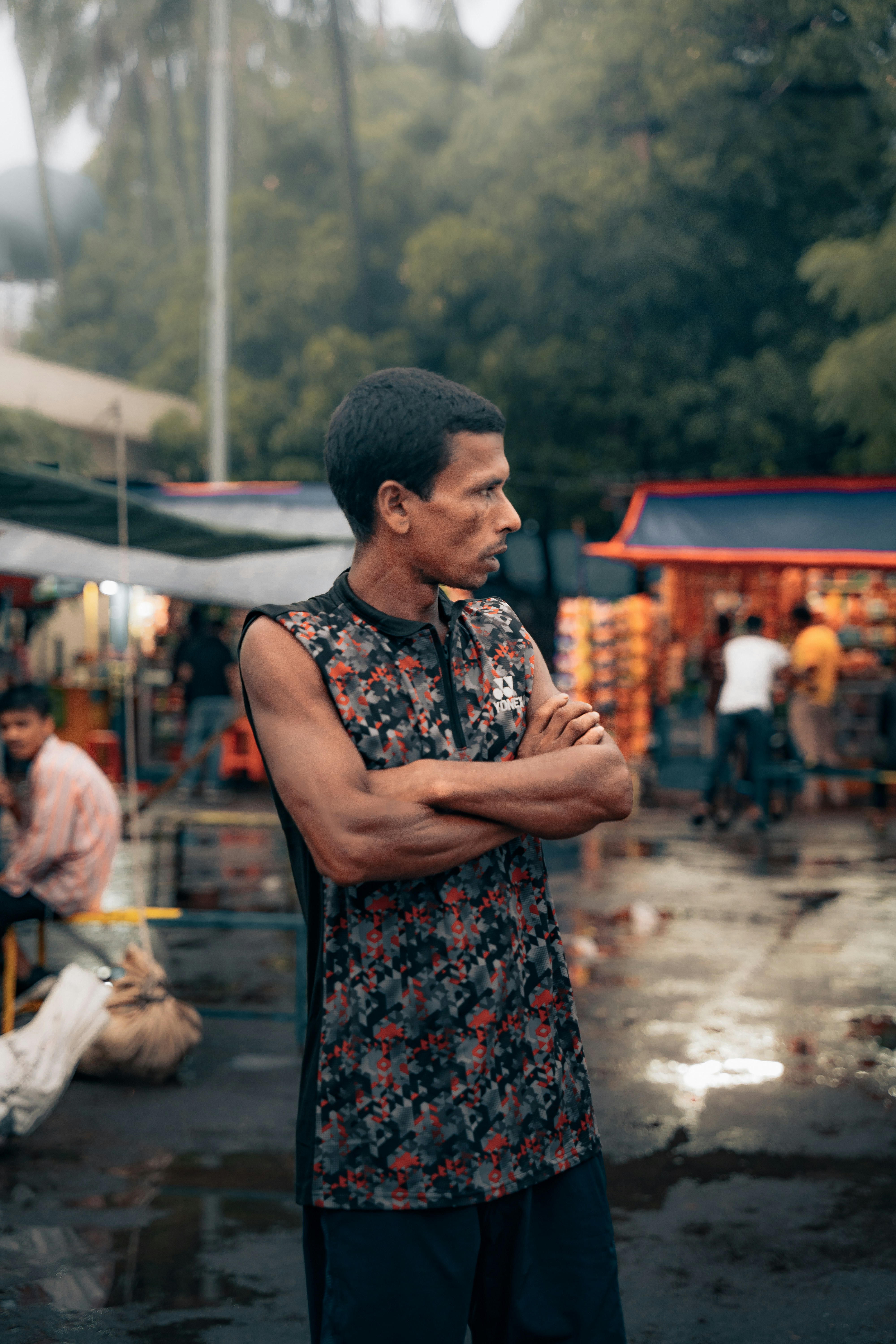 A man standing in the rain with his arms crossed