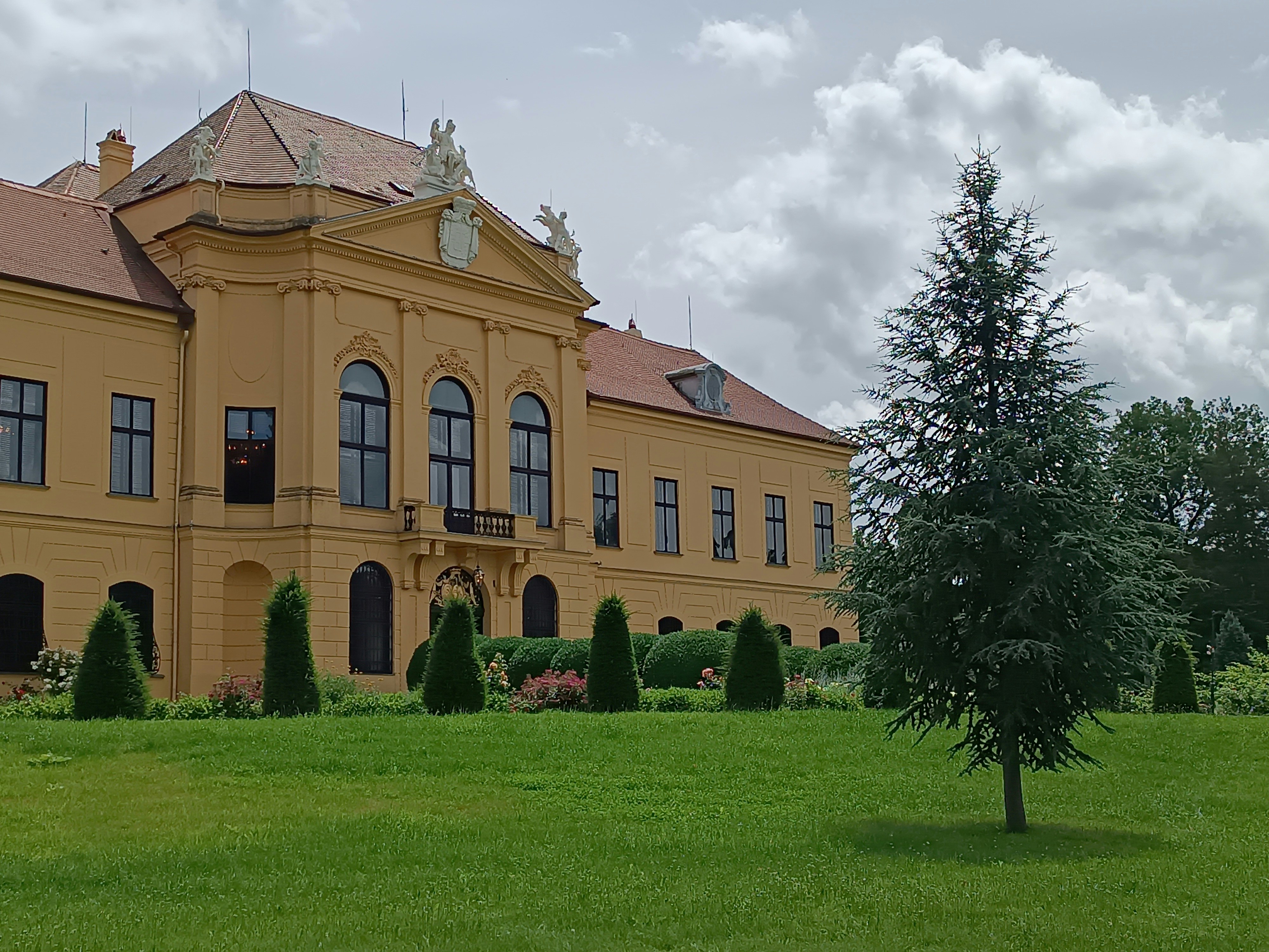 A large yellow building sitting on top of a lush green field