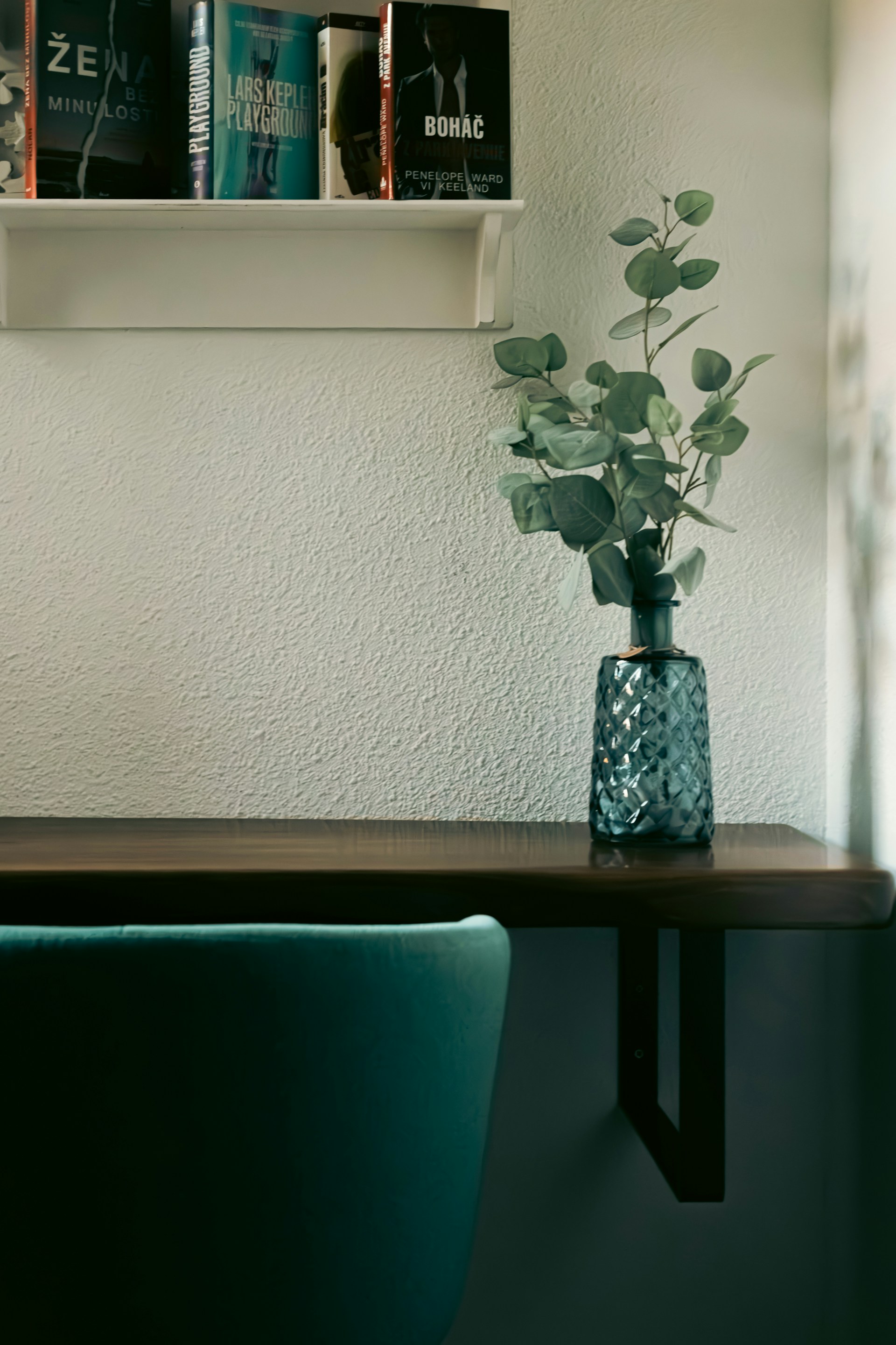 A table with a vase of flowers and books on it