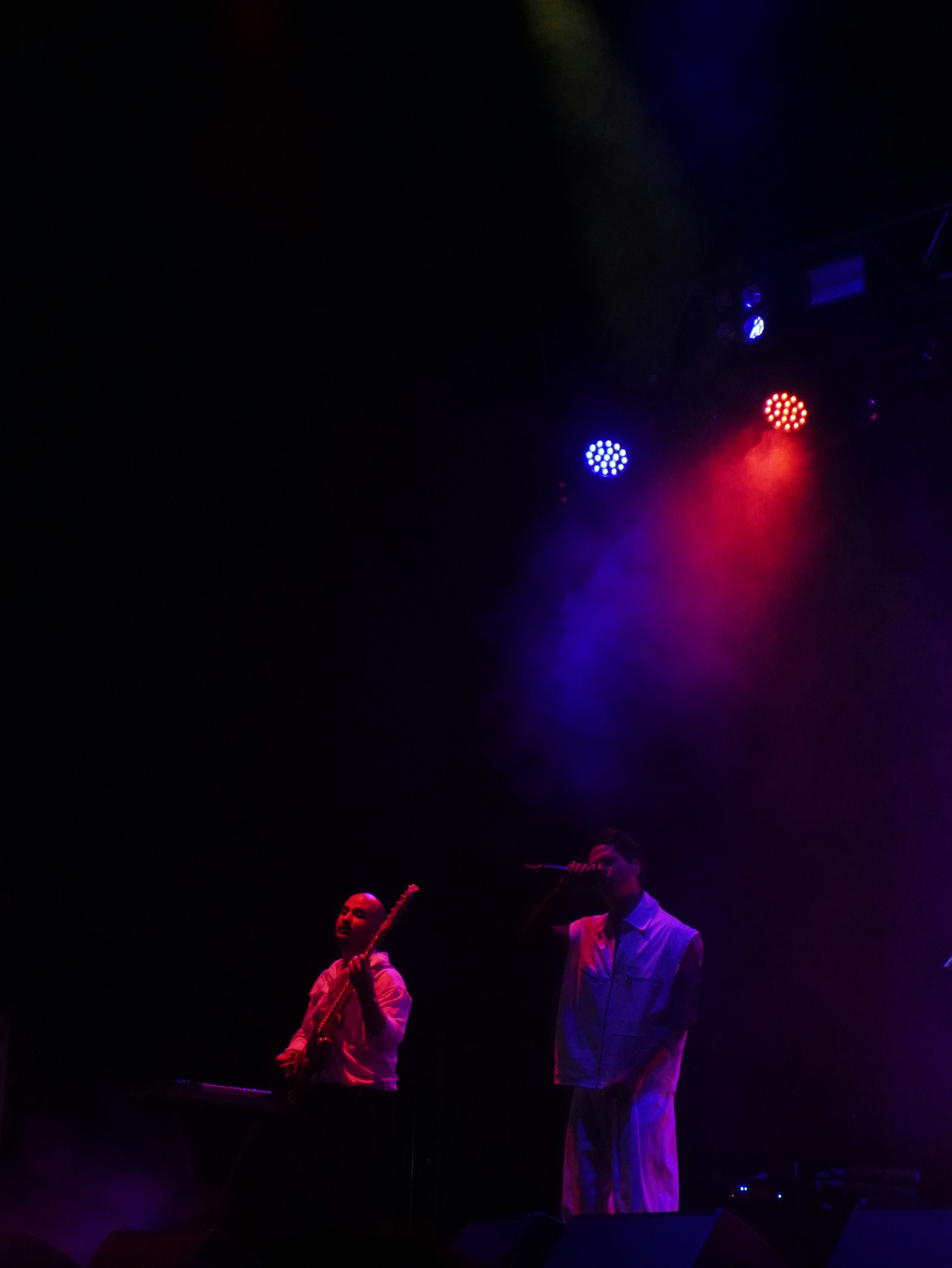 Group of musicians performing together on stage with colorful concert lighting