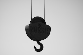 A black hook is hanging from a wire