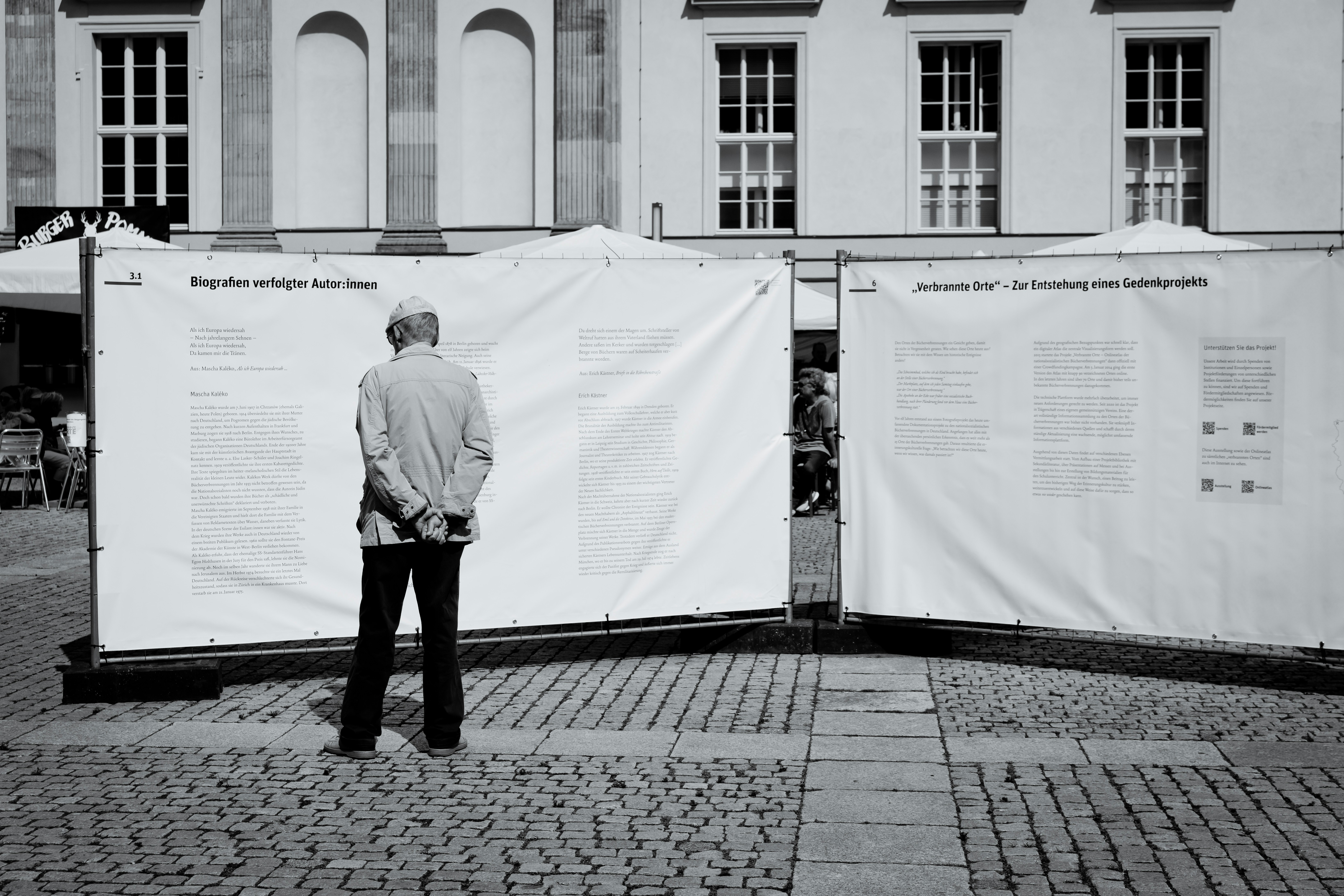 A man standing in front of a white building
