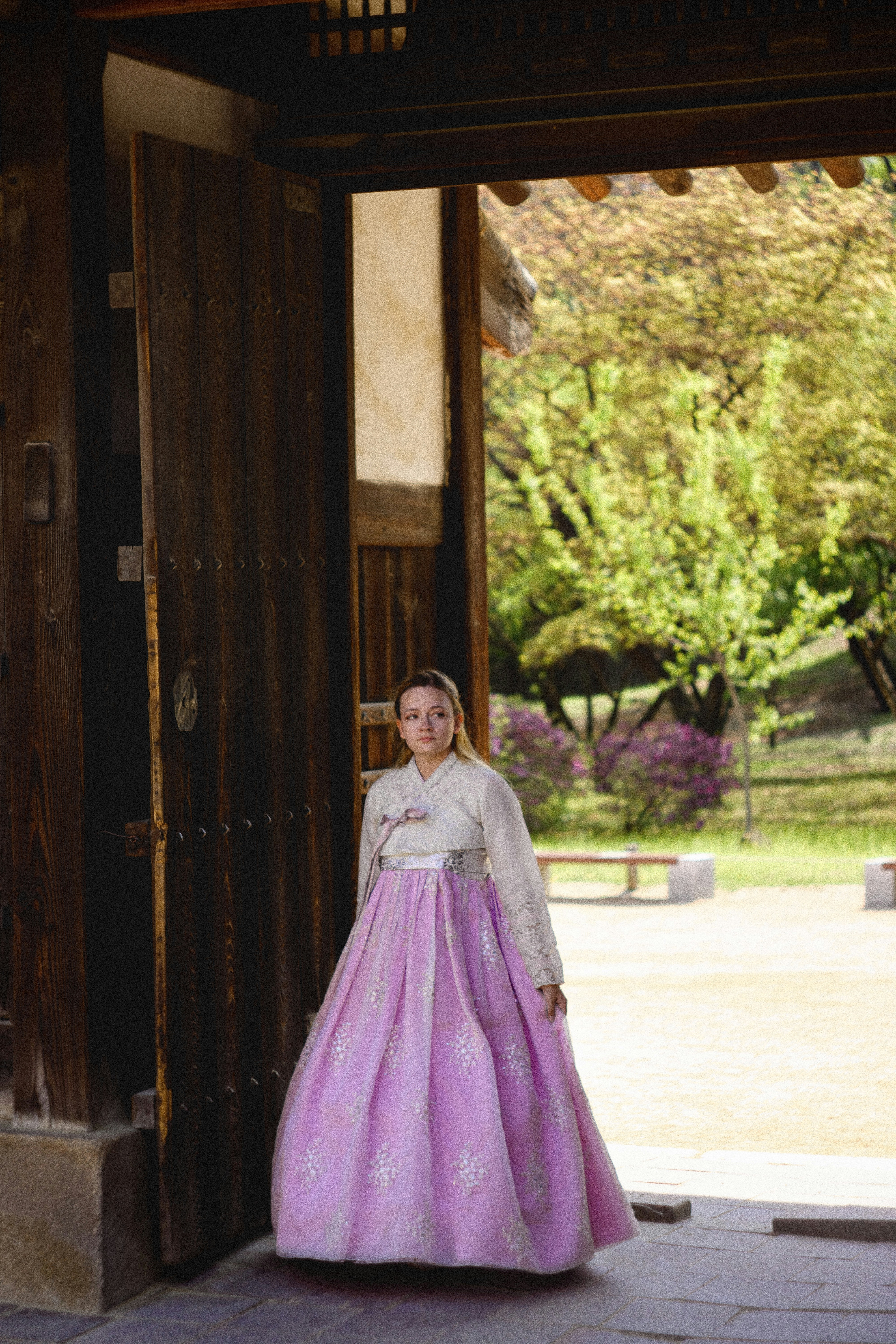A woman in a pink and white dress standing in a doorway