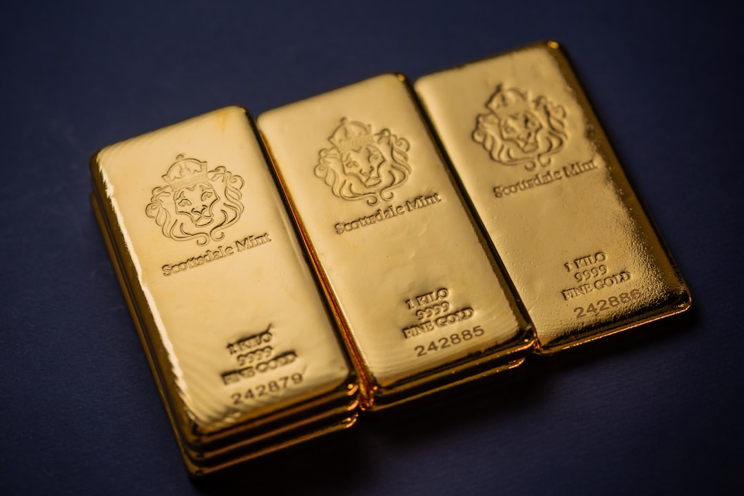 Three gold bars sitting next to each other on a table, Scottsdale Mint 1 Kilo Gold Bullion Bars sitting on a simple textured backdrop. Each bar is pure 9999 Fine and made from gold precious metals. Please give a shoutout to Scottsdale Mint if able! Shop online for the most beautiful bullion at ScottsdaleMint.com!