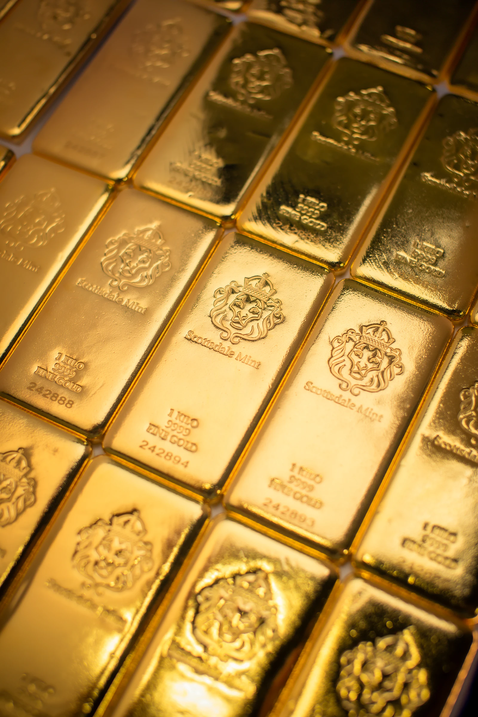 Gold bullion bars arranged on a dark textured surface