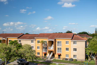 An apartment complex with cars parked in front of it