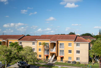 An apartment complex with cars parked in front of it