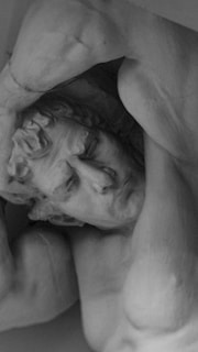 A statue of a man holding his head in his hands
