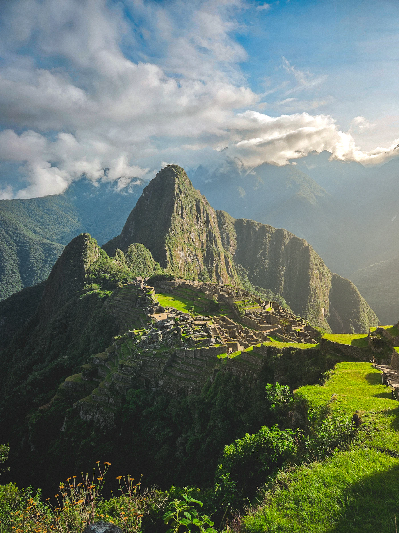 Aerial panoramic view of Machu Picchu Peru with the ancient Inca citadel surrounded by the Andean mountains and the deep green cloud-forest canyon of the Urubamba River below