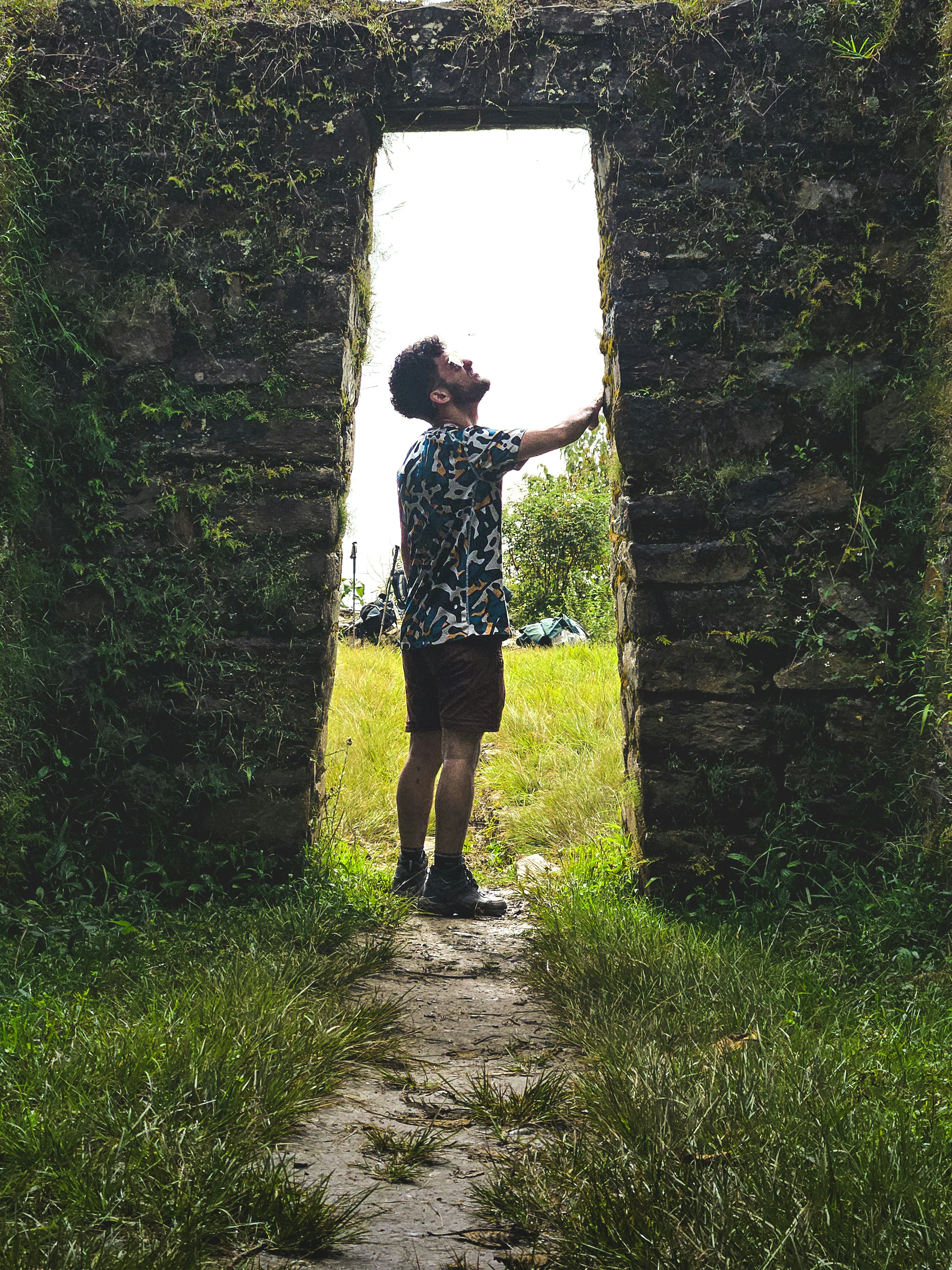 A person standing in the middle of a stone archway