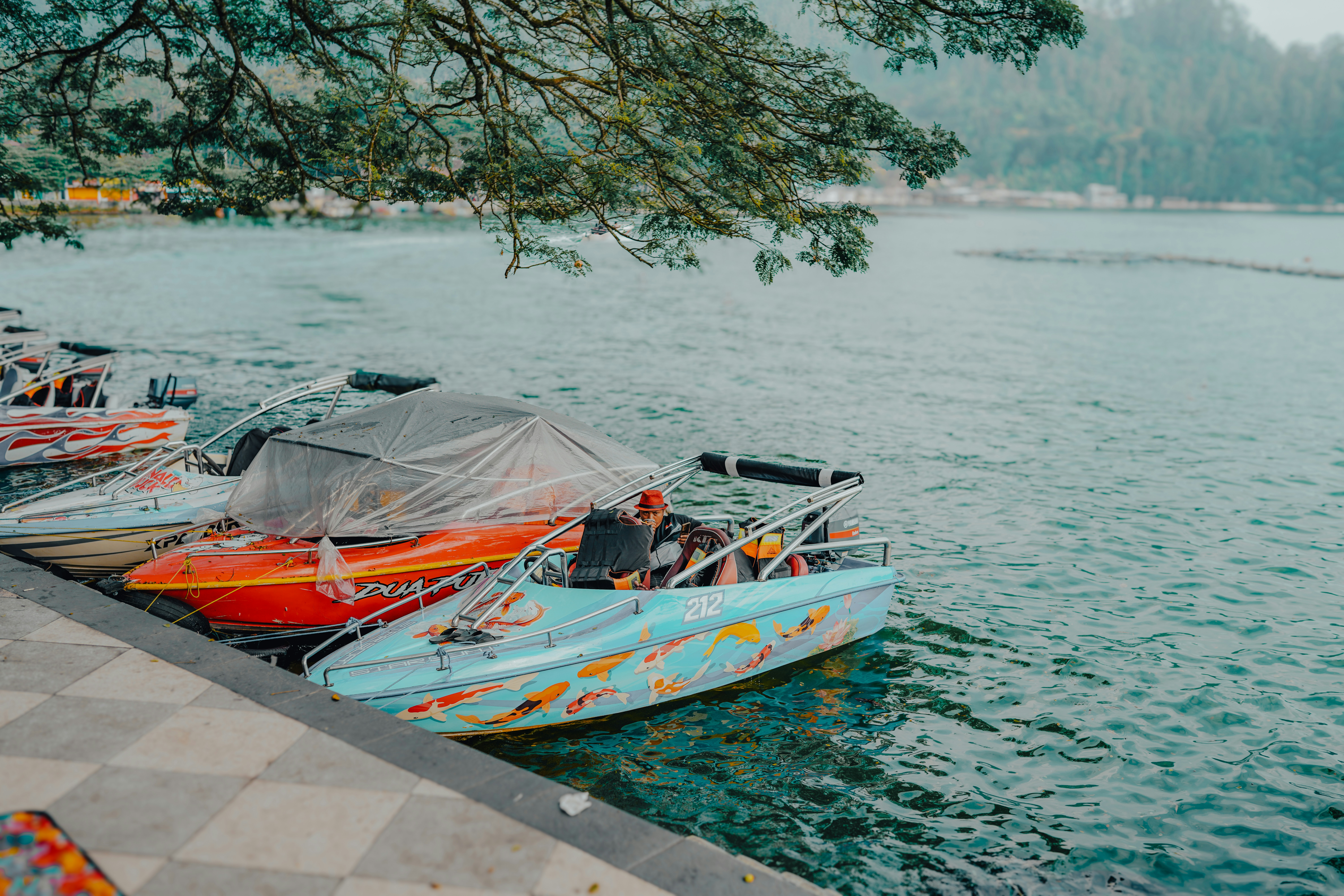A row of boats sitting on top of a body of water