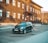 A small blue car parked in front of a building