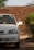 A white car parked in front of a brick wall