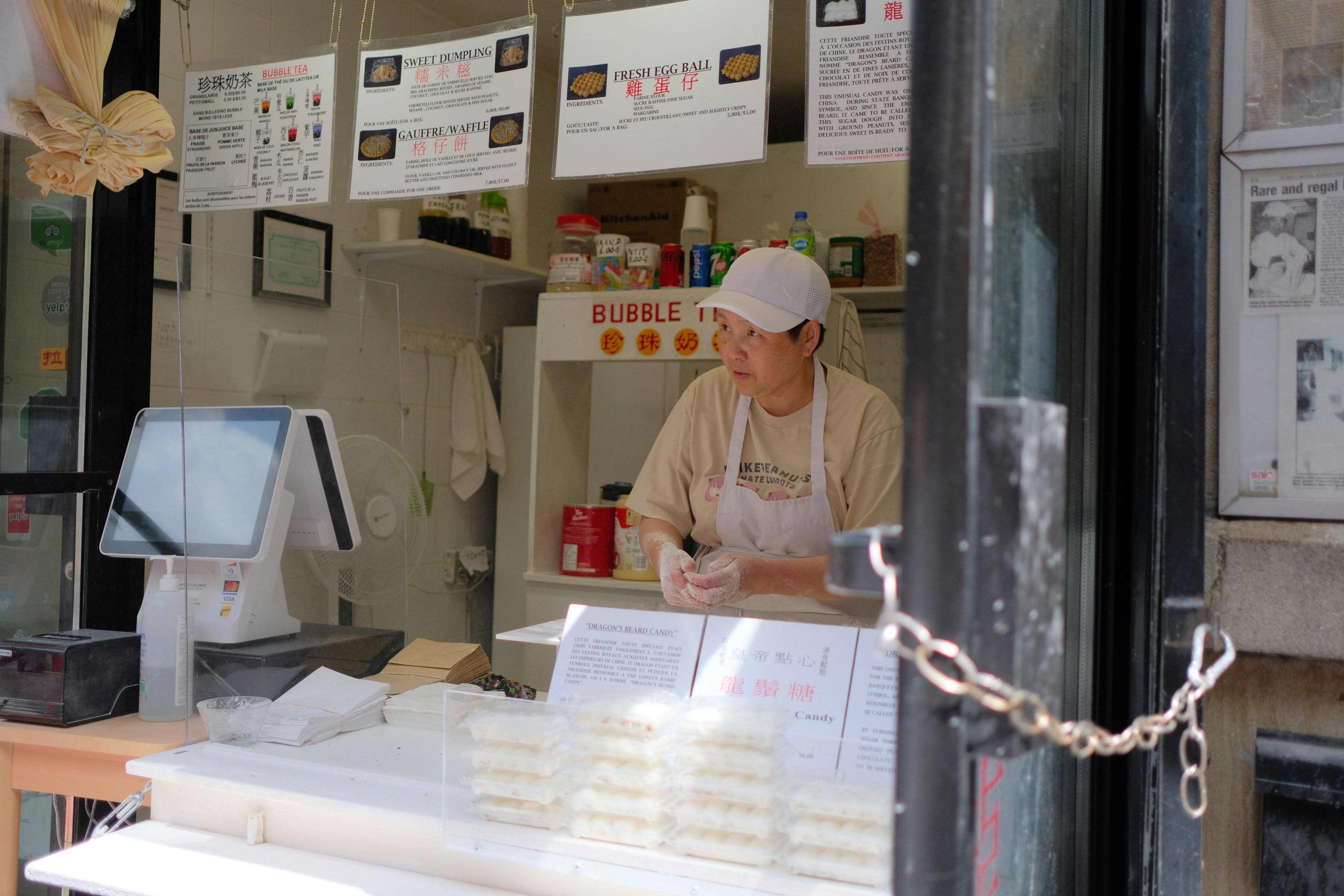 A man in a white hat is behind a counter