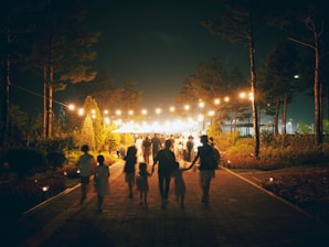 A group of people walking down a street at night