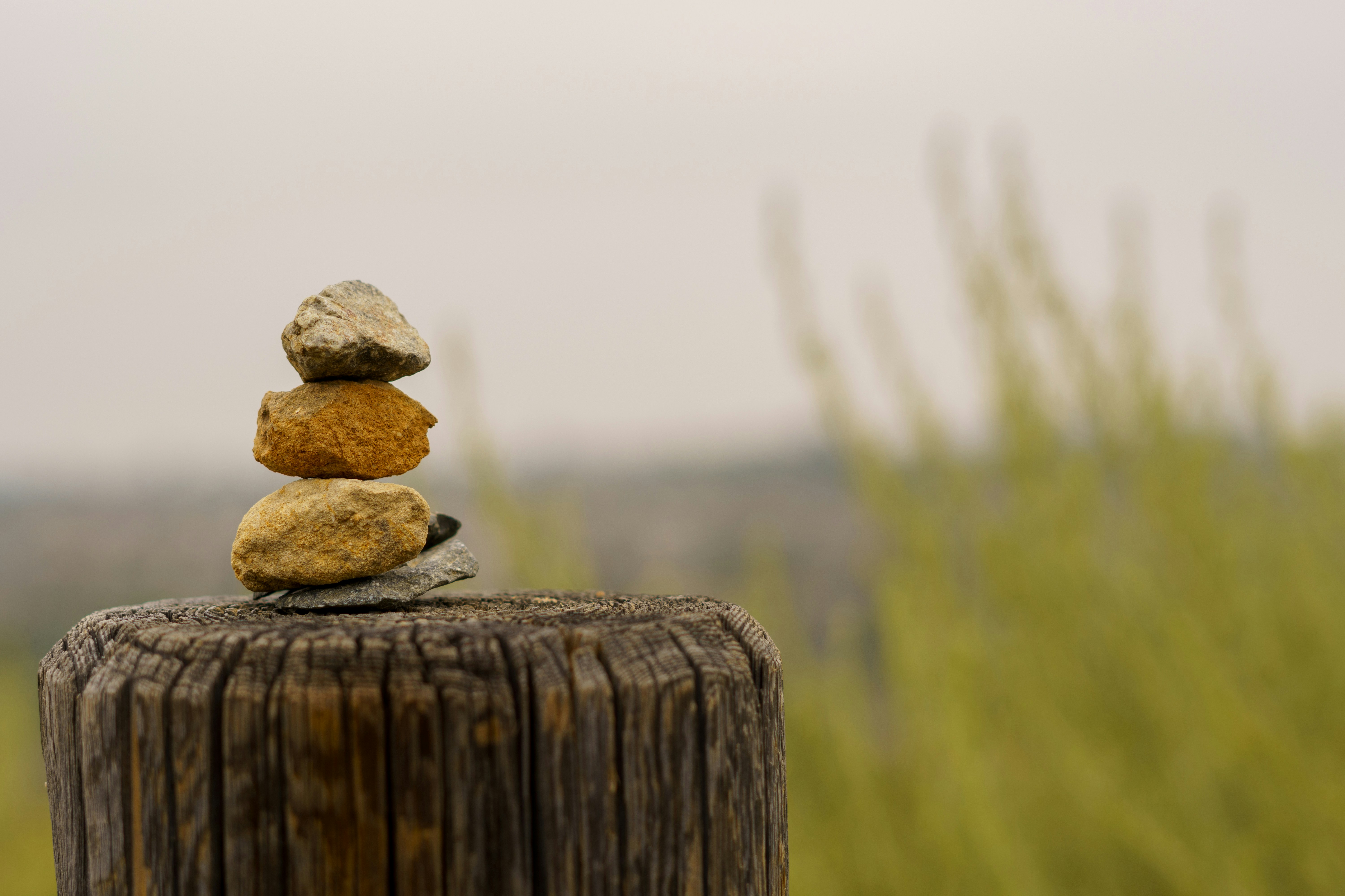 A stack of rocks sitting on top of a wooden post