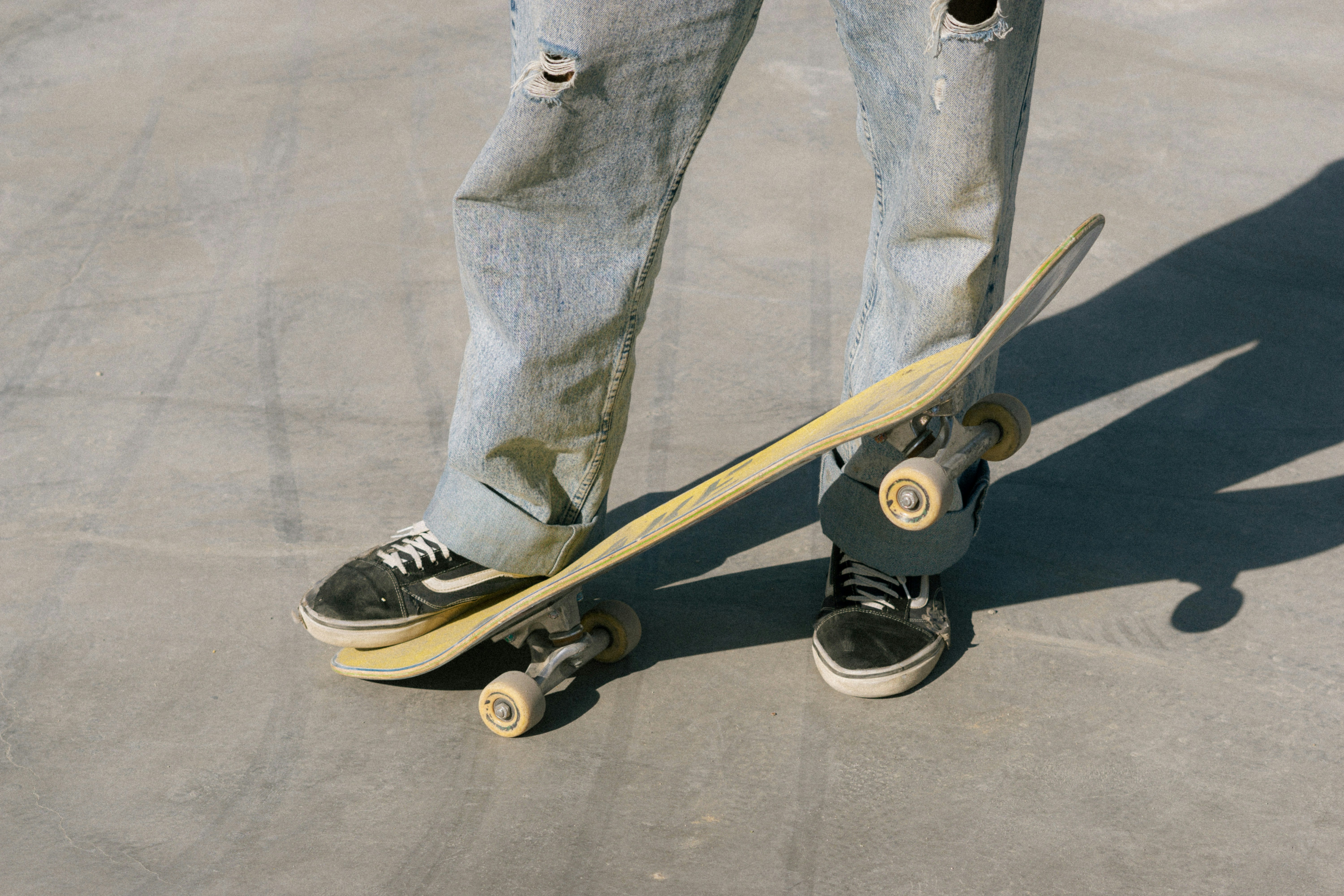 A person standing on a skateboard in a parking lot