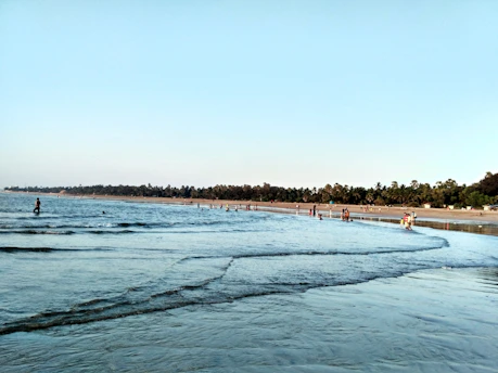 A body of water with a beach in the background